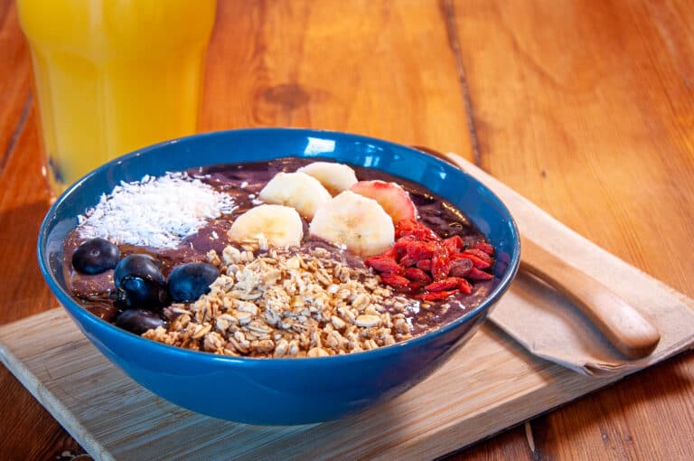 An acai bowl topped with granola, banana and berries.